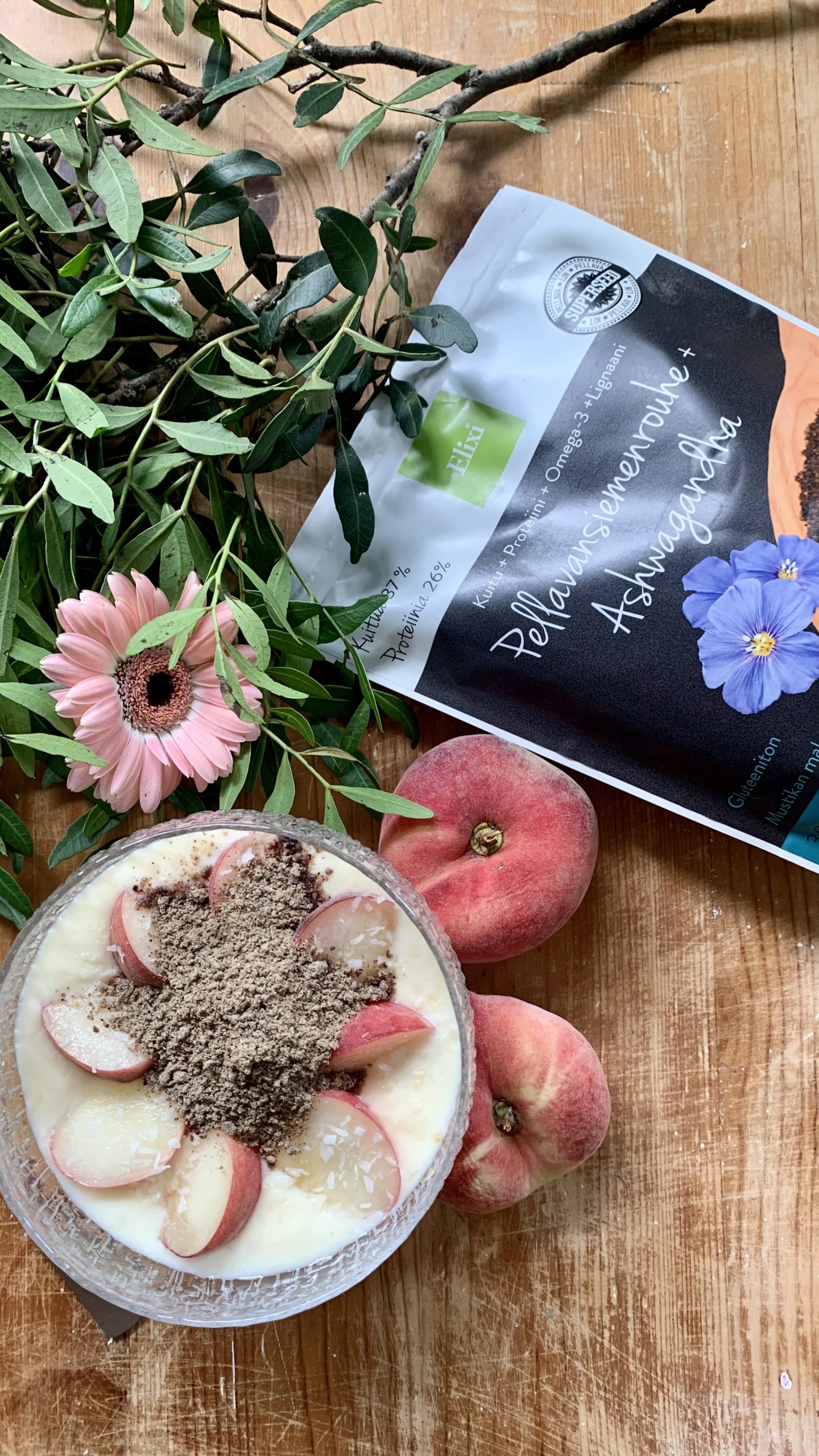 Ashwagandhalla on lukuisia terveysvaikutuksia Kulhollinen jugurttia jonka päällä on persikkalohkoja ja pellavansiemen & ashwagandha rouhetta
